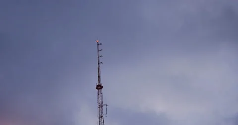 4K LOW ANGLE EVENING CLOUDS MOVING BEHIND CELL TOWER Video stock 132601911