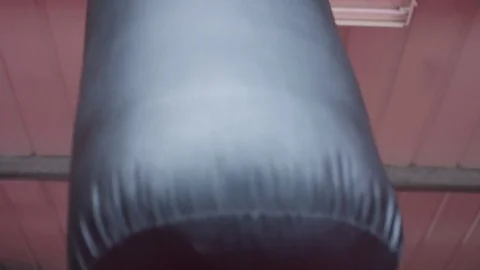 4K Low angle of female fighter training on a punchbag Video stock 73398253