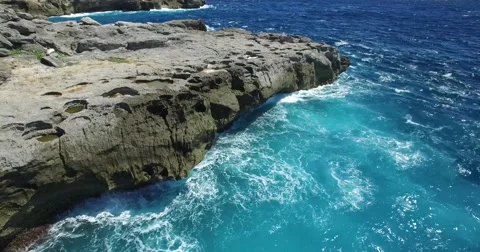 4K LOW ANGLE REVERSE AERIAL SHOT OF OCEAN WAVES &amp; ROCK CLIFFS Stock Footage 59999676