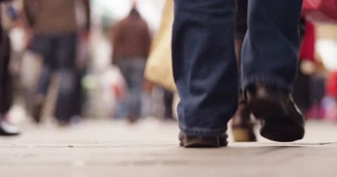4K Low angle view of unrecognizable shoppers walking through a busy city street Stock Footage 48124912