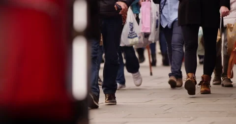 4K Low angle view of unrecognizable shoppers walking through a busy city street  Stock Footage 48125792