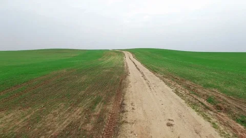 4K. Low flight above green hills with dirt road, aerial panoramic view. Stock Footage 71895293