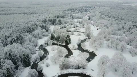 4K. Low flight above winding river in frozen forest at foggy weather. Aerial. Video stock 83402548