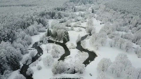 4K. Low flight above winding river in frozen forest at foggy weather. Aerial. Video stock 83402789