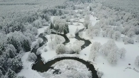 4K. Low flight above winding river in frozen forest. Aerial winter valley view. Video stock 83402947