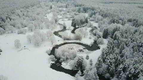 4K. Low flight above winding river in frozen forest at foggy weather. Aerial. Video stock 98216701
