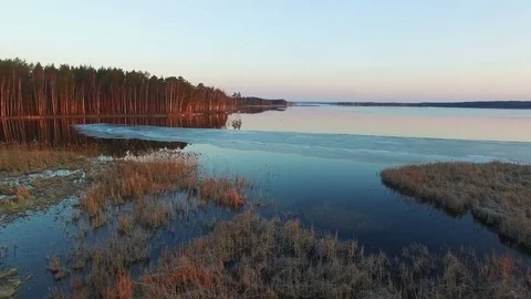 4K. Low flight over wild frozen lake in winter on sunset, aerial view. Video stock 82176226