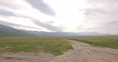 4k Low flying Over Dirt Road into California Mountains RAW Stock Footage 74112567