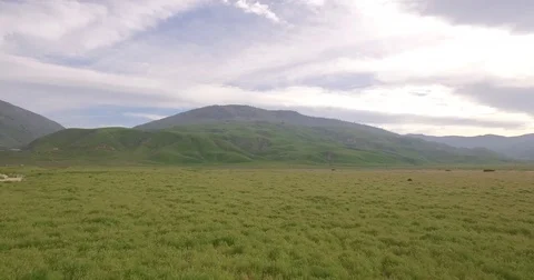 4k Low flying Over Green Field into California Mountains RAW Stock Footage 74113433