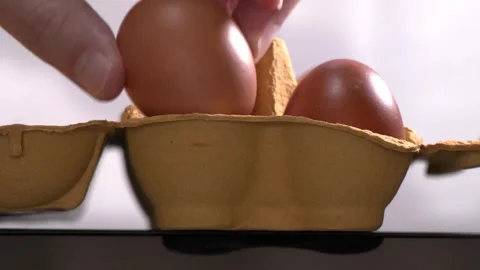 4K macro footage of man taking two eggs from yellow cardboard package Stock Footage 311127196