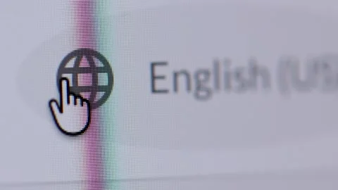 4K macro shot of a cursor clicking a globe icon to select a language, showing En Stock Footage 342777971