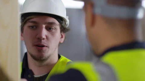 4k Male construction worker or tradesman working with male apprentice Stock Footage 54034577