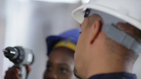 4k Male construction worker or tradesman working with female apprentice Stock Footage 54041576