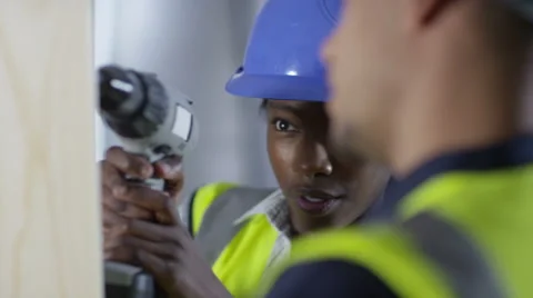 4k Male construction worker or tradesman working with female apprentice Stock Footage 54099351