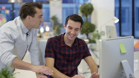 4K Male designers looking at computer &amp; collaborating in creative office Stock Footage 76005740