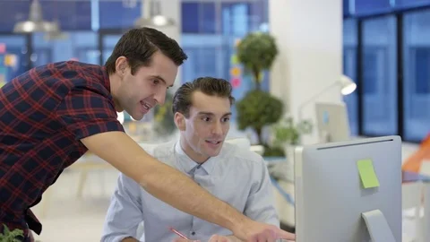 4K Male designers looking at computer &amp; collaborating in creative office Stock Footage 76006336