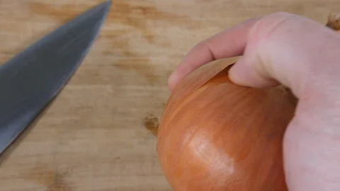 4K man chef hand peeling skin of brown onion for cooking with in kitchen Stock Footage 88486871
