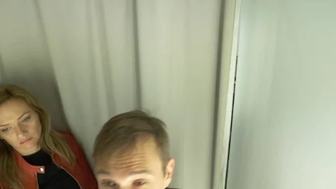 4k, A man chooses clothes for himself in a clothing store. Trying on new clothes Stock Footage 82911699