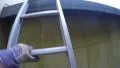 4K man climbing ladder on a yellow house to clean drainpipe and gutters 4k or 4k+ Resolution