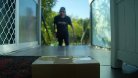 4K Man Collecting Package from Front Porch and Carrying Delivery into Home Stock Footage 341053946