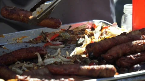 4k. Man cooking Bacon Wrapped Sausages with Vegetables on a Pan in Street Cafe. 스톡 동영상 101551672