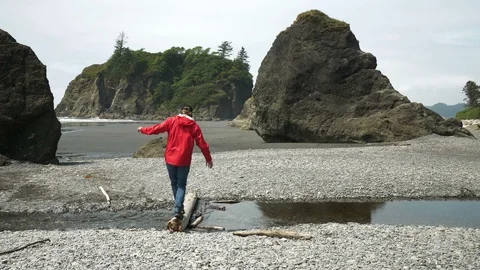 4K Man Crosses Log in Stream at Epic Pacific Northwest Beach Video stock 109042249