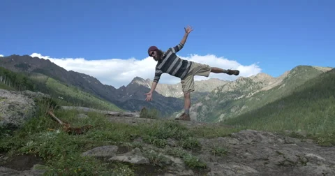 4k Man does yoga in the middle of a Colorado mountain valley Stock Footage 56568526