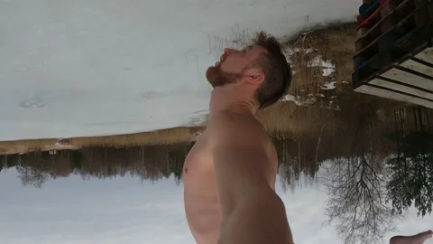 4K man doing a backflip into an ice hole in winter from a platform Stock Footage 157013064