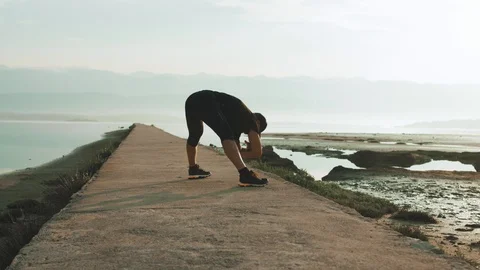 4K Man Doing Stretch Exercises In The Morning At A Beach Stock Footage 93071856