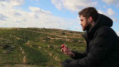 4k Man Eating Red Apple In Countryside Landscape Video stock 101427730