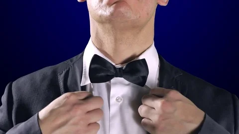 4K Man Fixing Bow Tie, Close Up Tuxedo Suit, Dark Blue Background Stock Footage 71745443
