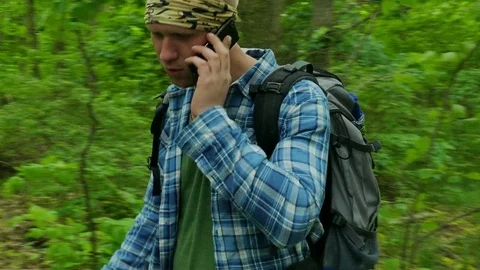 4K. Man Hiker in Forest  talking by mobile phone,steady shot.  Stock-Footage 76465229