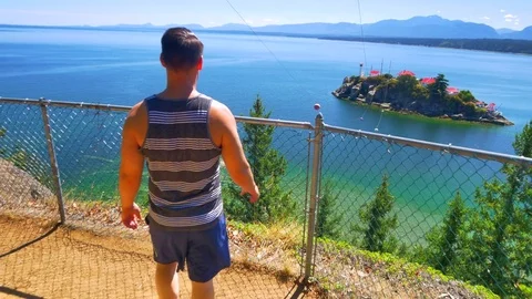 4K Man Hiking Up Mountain Peak to View of Island Ocean Landscape Video stock 78941555