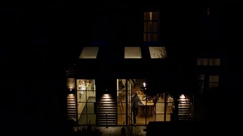 4K Man locking up his city home &amp; turning off the lights at night Stock Footage 71384420