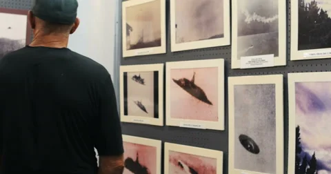 4K man looking at UFO photographs in museum Stock Footage 54049853