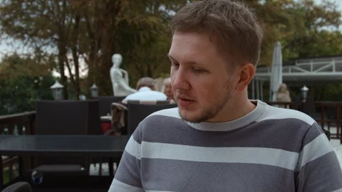 4K A man makes an order in a outside part of a cafe by turning the pages of the Stock-Footage 99934033