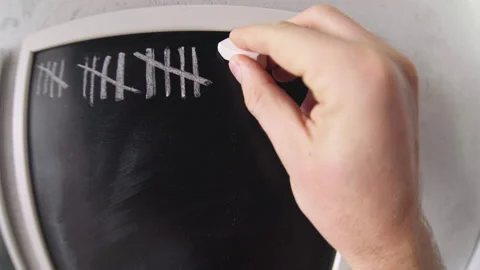 4K Man making dashes with chalk on blackboard crossing them off Stock-Footage 145445192