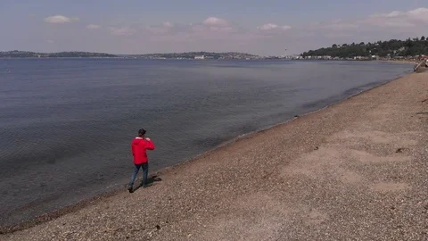 4K Man In Red Raincoat Walks Down Alki Beach Space Needle Video stock 109423391