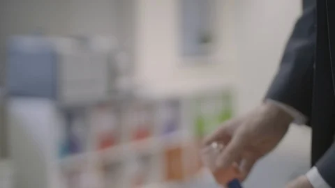 4k Man rubbing hand sanitiser into his hands at work Stock Footage 126737871