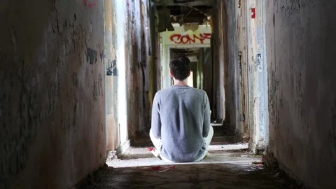 4K Man sitting in abandoned hall way Stock Footage 70319132