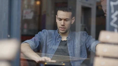 4K Man Sitting Alone In Cafe Using Computer Tablet &amp; Drinking Coffee Stock Footage 75691755