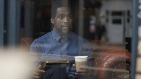 4K Man Sitting Alone In Cafe Using Computer Tablet &amp; Drinking Coffee Stock Footage 75693094