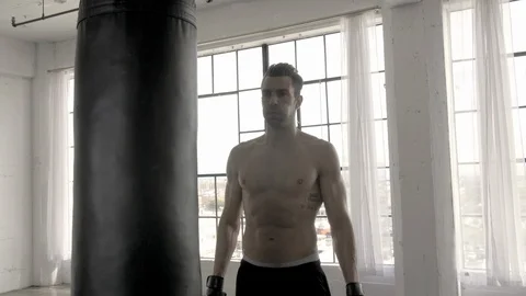 4K man standing heroically next to punching bag 스톡 동영상 109583996