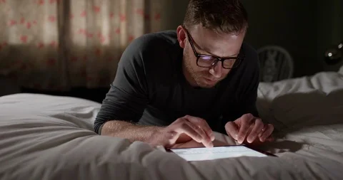 4K Man typing email message on touchscreen computer, in his bedroom at night. Stock Footage 107280154