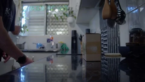 4K Man Unboxing LED Puck Light in Modern Kitchen Using Kitchen Knife Stock Footage 341054721