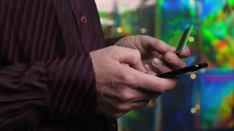 4K Man using a credit card and smartphone on a festive background. Holiday sale. Stock Footage 166275252