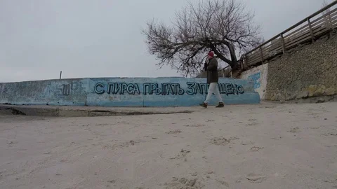 4K Man Walking On Beach, Jumping Off Pier Prohibited - Odesa, Ukraine, JAN 2018 動画素材 84123434