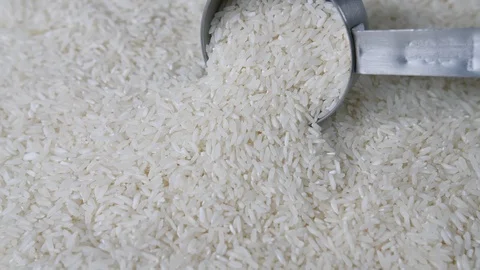 4K mans hand taking measuring cup from sack of white rice grain pile Stock Footage 88483053