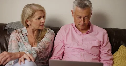 4K Mature couple with relationship problems man ignoring wife while using laptop Stock Footage 84144945