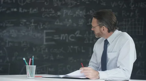 4K Mature man in classroom studying math formulas on blackboard Stock Footage 67879378